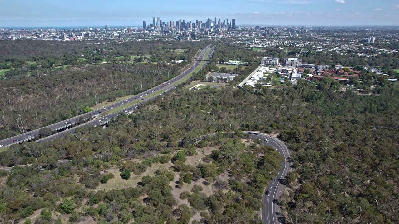 Aerial view looking west over the Wurundjeri Spur Lookout and Eastern Freeway to the Melbourne city skyline, Victoria, Australia. March 2025