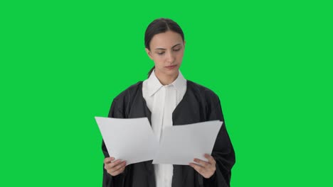 Serious-Indian-female-lawyer-reading-case-files-Green-screen