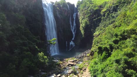 drone shot of mpumalanga in south africa - drone is reversing from a waterfall in a natural valley