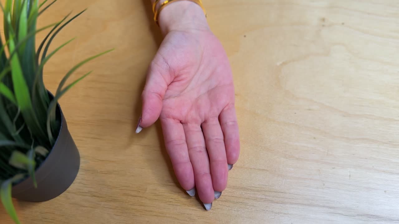 Detailed 4K close-up of a hand holding a modern car key with a cute astronaut charm on a wooden surface. Perfect for auto, tech, or lifestyle use.