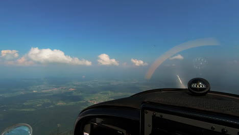 adventure of flying, pilots point of view from the cockpit of light aircraft, compas with magnetic windrose on dashboard, freedom above the clouds