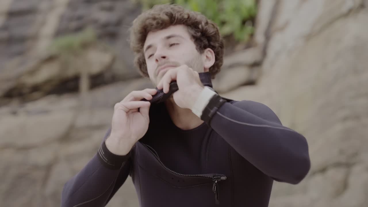 Man Putting On Wetsuit for Water Sports