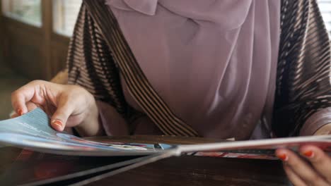 woman reading a restaurant menu in a cafe