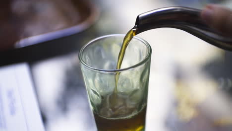 marruecos, hombre sirviendo té en vaso pequeño en un riad en marrakech cámara lenta