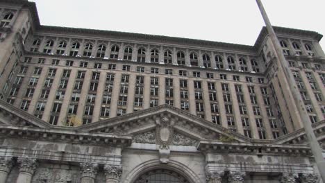 pan shot of smashed windows and broken facade of michigan central station in detroit