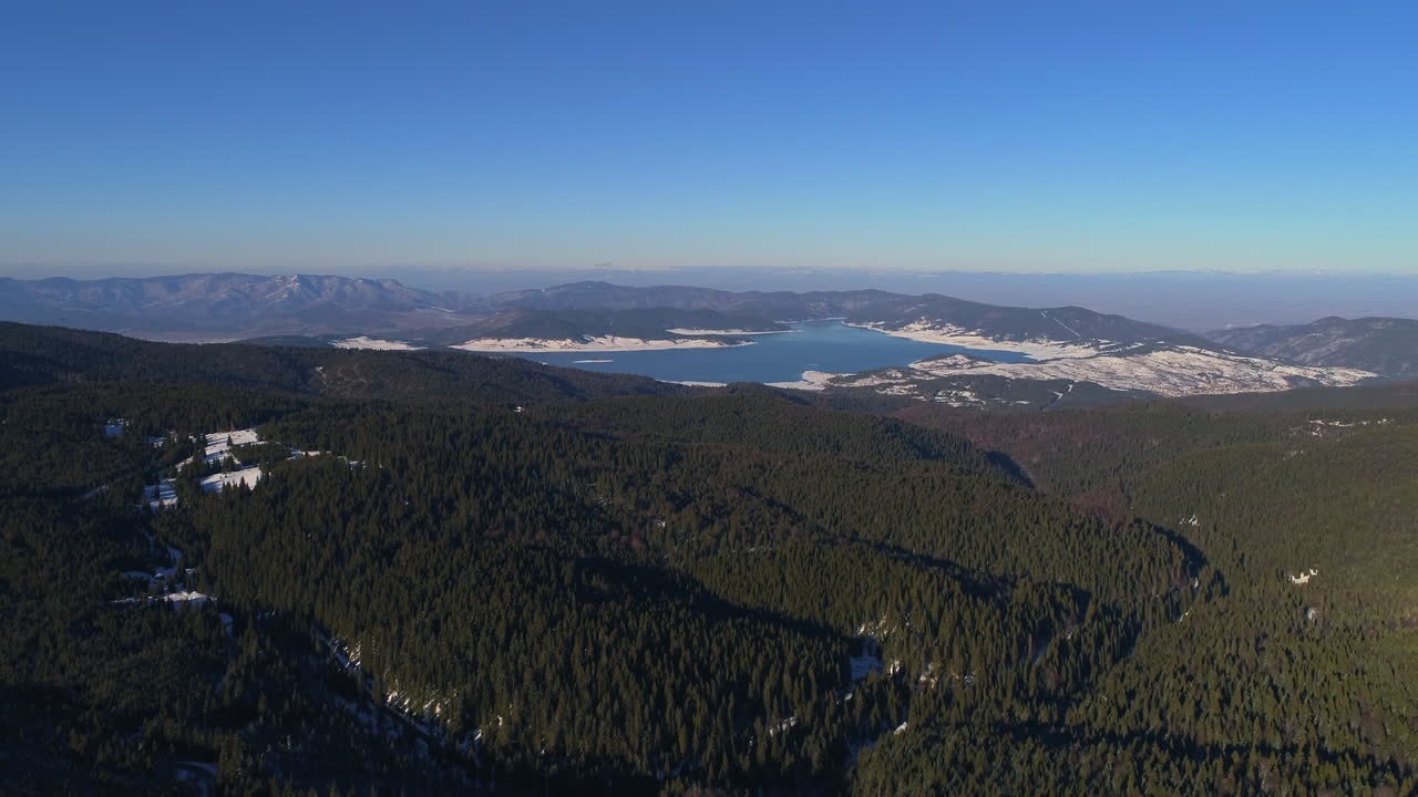 공중: 눈과 숲으로 뒤덮인 산간 지역 위를 날다