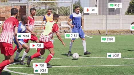 Animation-Von-Social-Media-Symbolen-über-Verschiedenen-Männlichen-Fußballspielern,-Die-Auf-Dem-Sportplatz-Fußball-Spielen