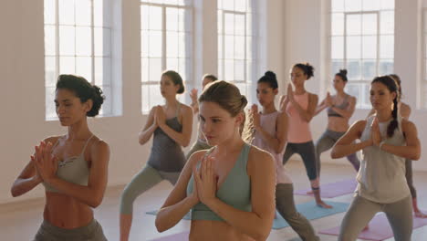 yoga class multi ethnic women practicing warrior pose enjoying healthy lifestyle exercising in fitness studio at sunrise