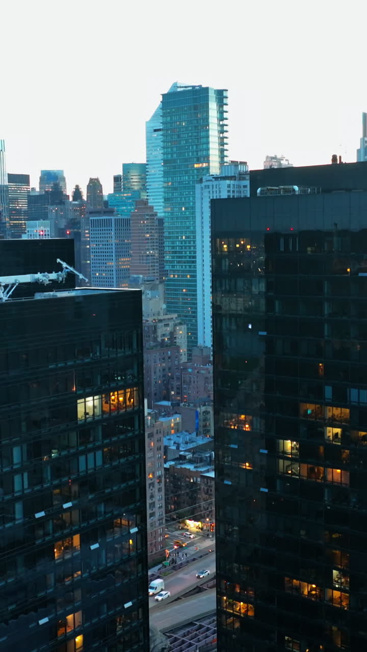 Wonderful modern city architecture. Rising along the buildings with mirror windows reflecting lights. Vertical video