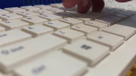 hand of man is typing white computer keyboard