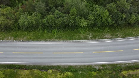 Vista-De-Arriba-Hacia-Abajo-Sobre-Un-Coche-Blanco-Que-Pasa-Por-Un-Lago-En-Noruega