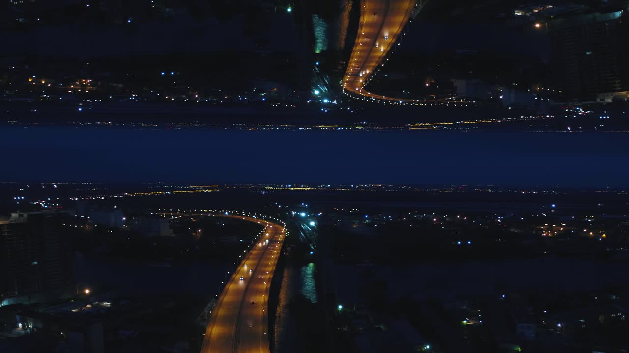 vista aérea nocturna de la ciudad con reflejo de la carretera
