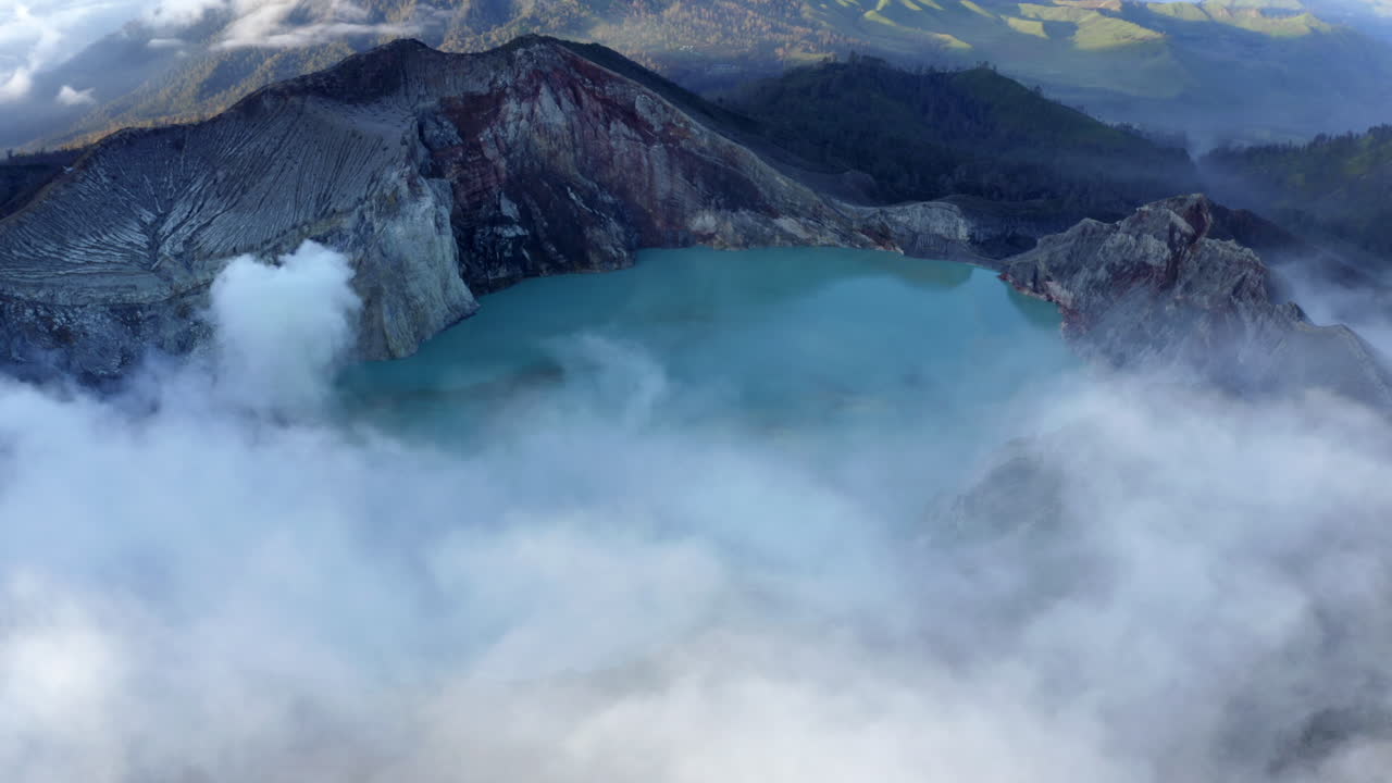 Mt. Ijen caldera lake with stream rising at sunrise in East Java, Indonesia
