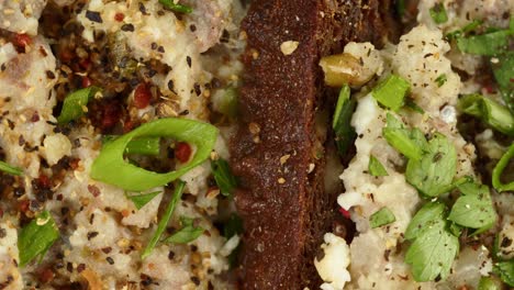 cocina israelí. forshmak con perejil y especias en pan de centeno negro de primer plano. plato nacional de arenque judío, cultura de oriente medio. bocadillo tradicional vorschmack hecho de filete de pescado giratorio
