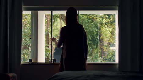 silhouette of young woman looking out of window, stay home in quarantine