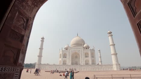 the taj mahal framed by one of the gates. approaching shot