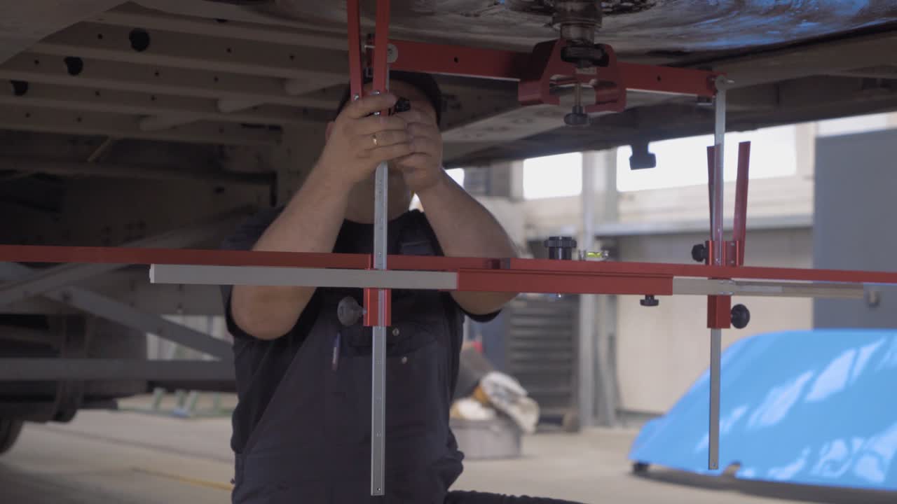 Meccanico auto controlla lo stabilizzatore dell'asse di un camion