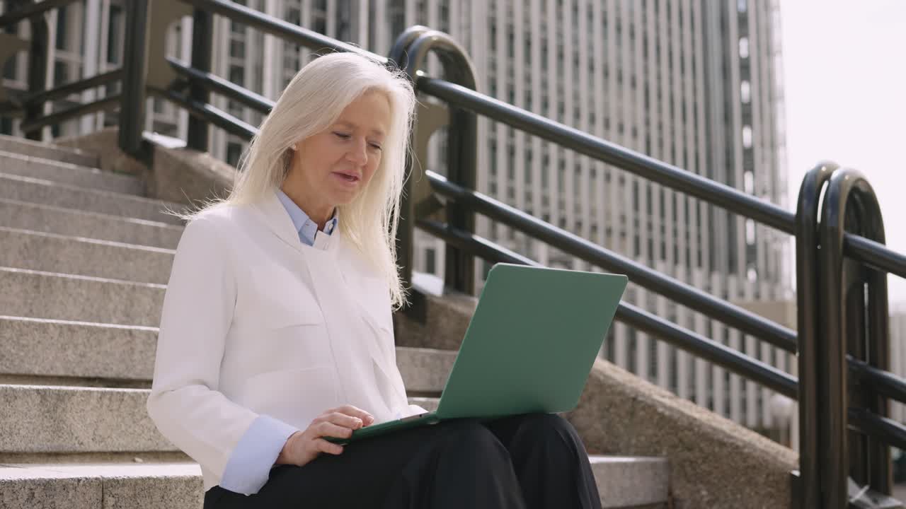 Businesswoman working on laptop outdoors