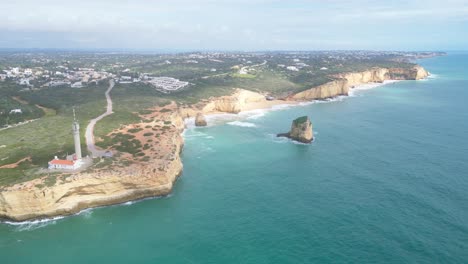 algarve coastline near ferragudo with lighthouse and sea cliffs, aerial view