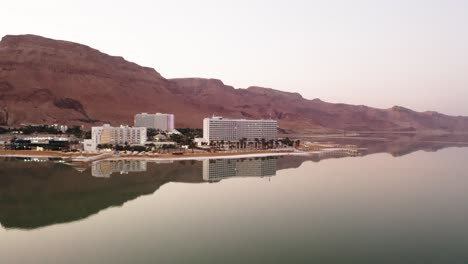 4K-Aerial-drone-tracking-dolly-shot-sunset-over-desert-dead-sea-hotel-zone