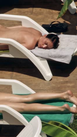 beautiful young women relaxing on the deck chair near the pool