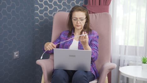 The-woman-unplugs-the-charger-from-the-outlet.