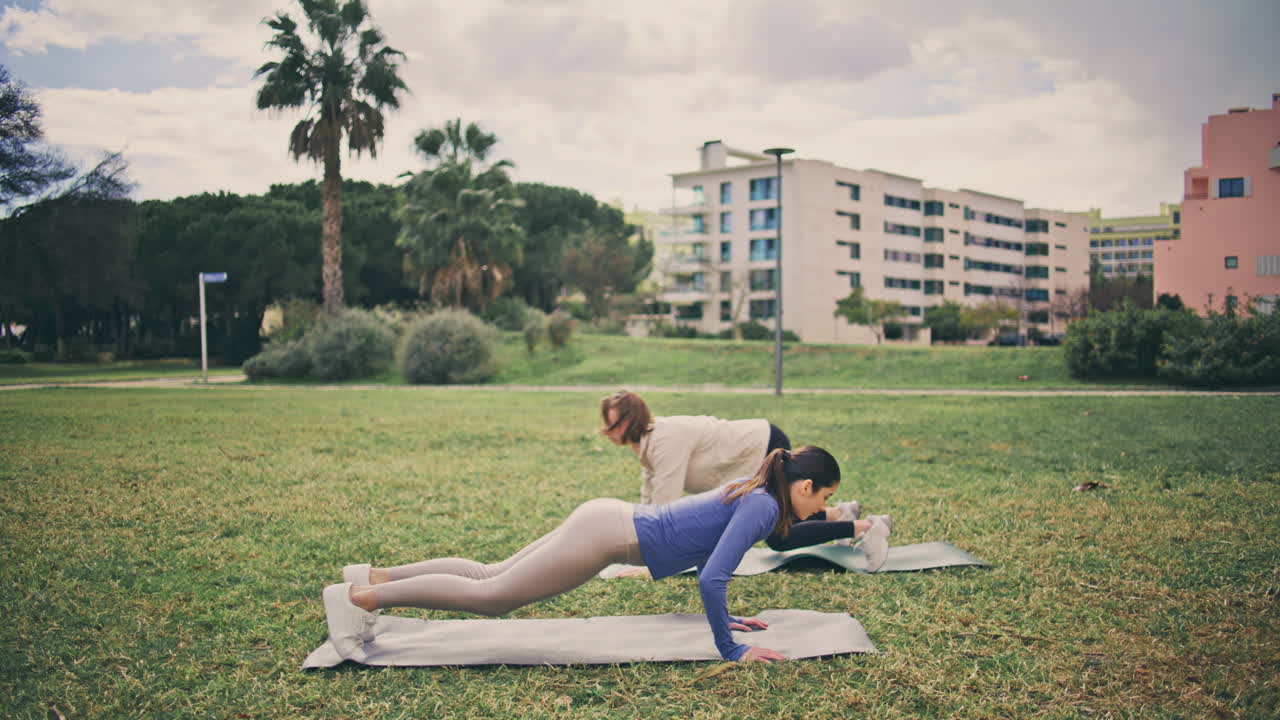 Strong athletes doing burpees workout glade. Women having cardio core exercise