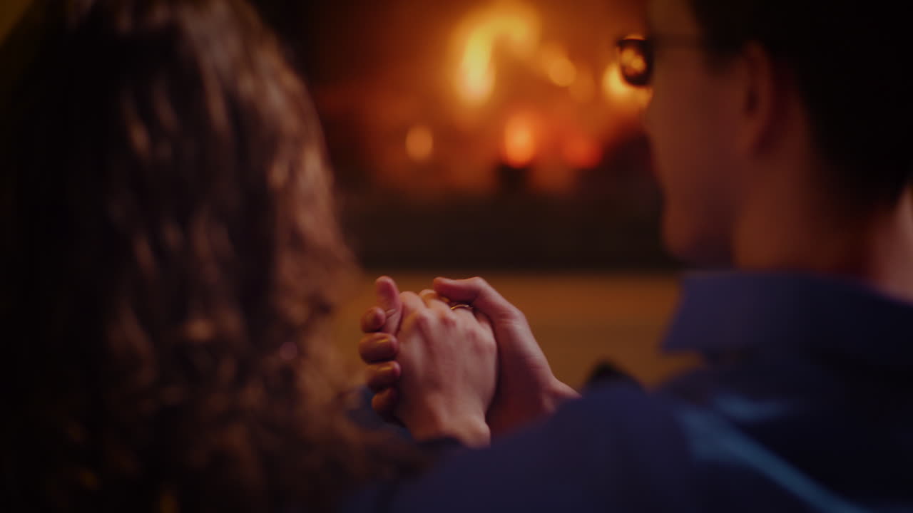 Couple holding hands by the fireplace