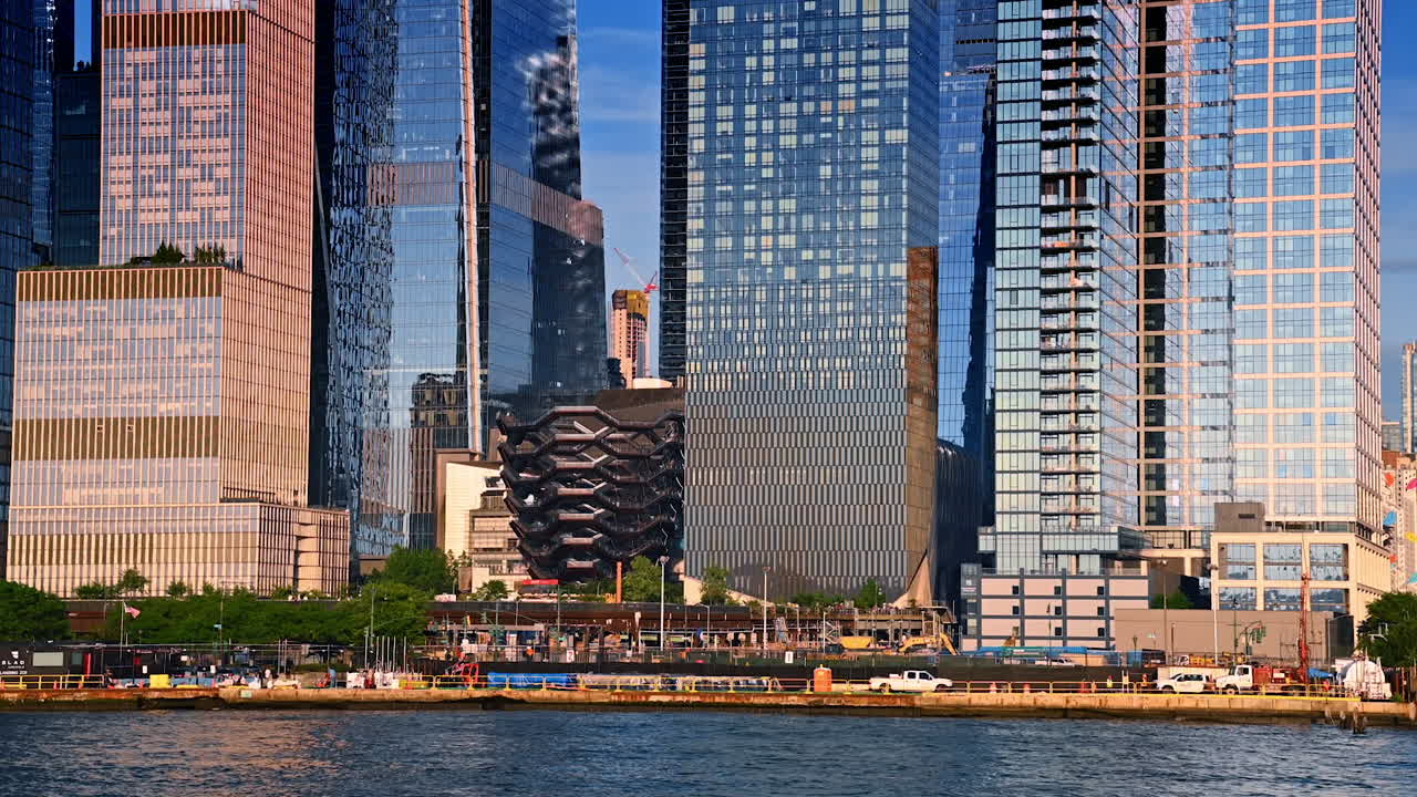 Modern skyscrapers of Hudson Yards in New York City. Aerial view of the Hudson Yards skyscrapers in Manhattan during sunset. The Vessel landmark is visible among the tall glass towers
