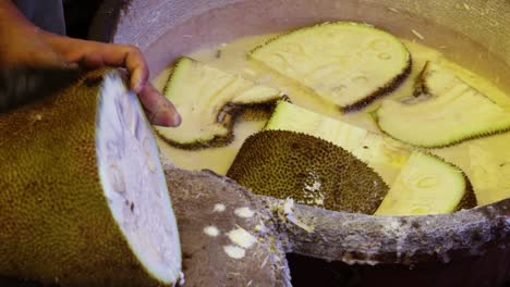 man chopping fresh organic unripe jack fruit for vegetable from farm close up shot