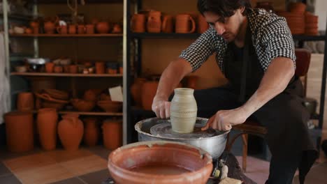 el ceramista mira su producto de arcilla casi terminado hecho a mano