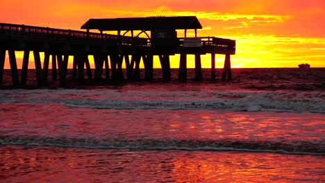 sunrise at tybee beach pier with deep orange colors