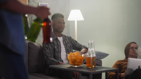 young man carries drinks to enjoy football with best friends