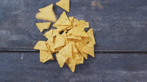 close up view of nachos falling on wooden tray with copy space on wooden surface