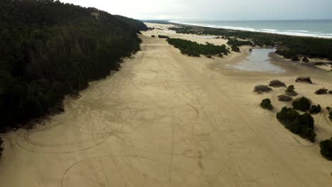 estados unidos, o, reedsport, playa de umpqua, 2024-11-24 - vista de avión no tripulado de las dunas de oregón en el faro del río umpqua con pistas de atv en la arena en un día lluvioso.