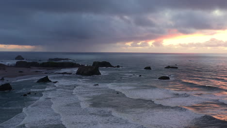 Dramatischer-Sonnenuntergang-An-Der-Oregon-küste-Mit-Sturmwolken-über-Felsen-Im-Ozean