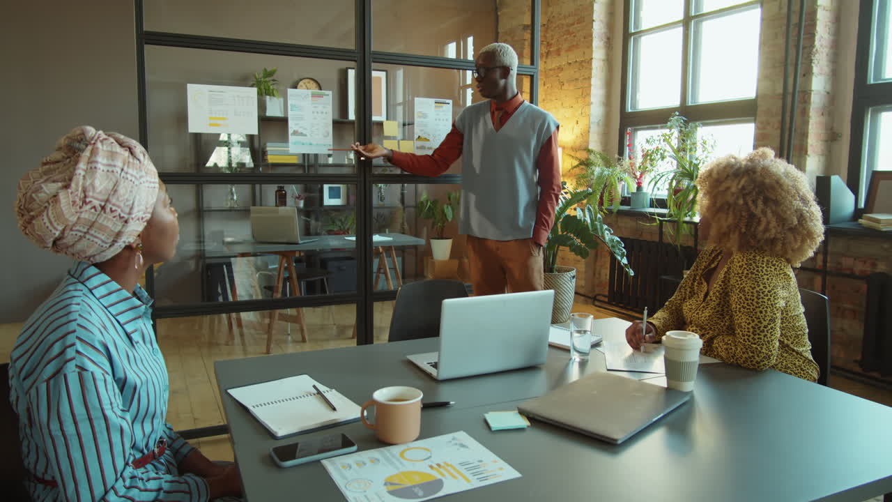 hombre afroamericano dando una presentación de negocios en una reunión de oficina