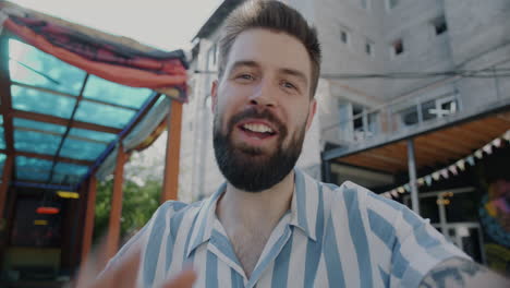 man smiling at a camera, likely on a video call.