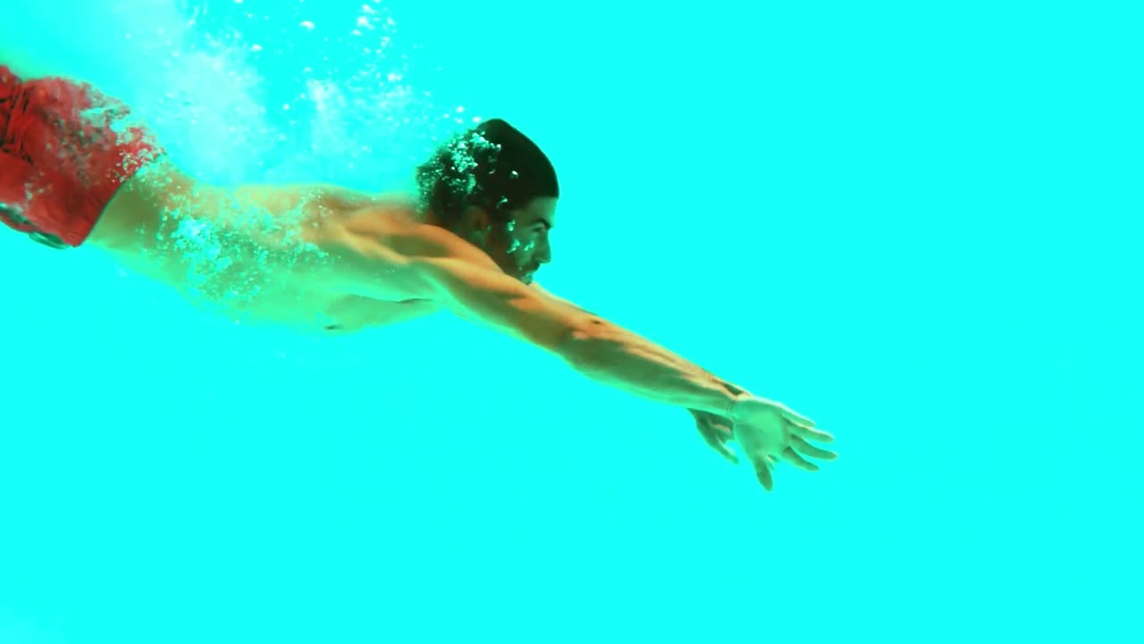 Handsome man swimming underwater