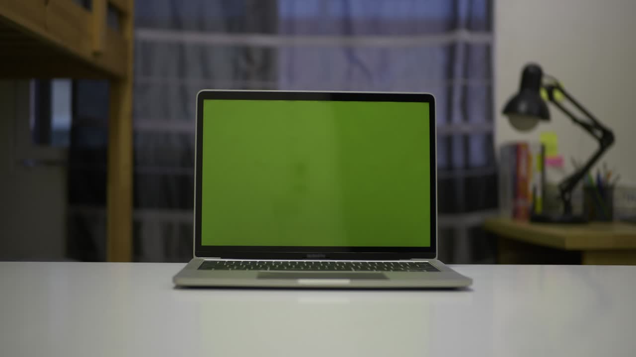 Slider shot of green screen laptop standing on the desk