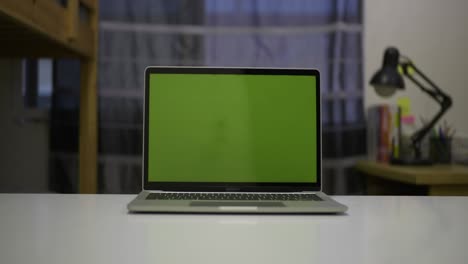 slider shot of green screen laptop standing on the desk