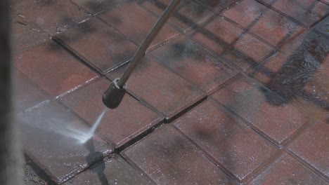 close up of a pressure washer cleaning a brick surface