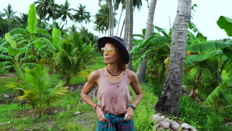 sexual redhead walking through palm tree forest, front view