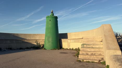 vista hacia atrás de un faro verde en una torreta