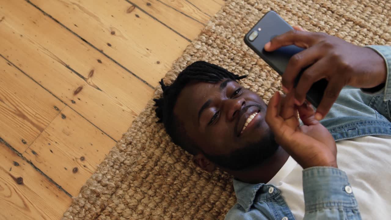 Man lying on the floor using smartphone