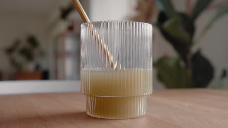 time lapse drinking a green healthy juice through a sustainable golden metal straw from a design drinking glass in the living room at home