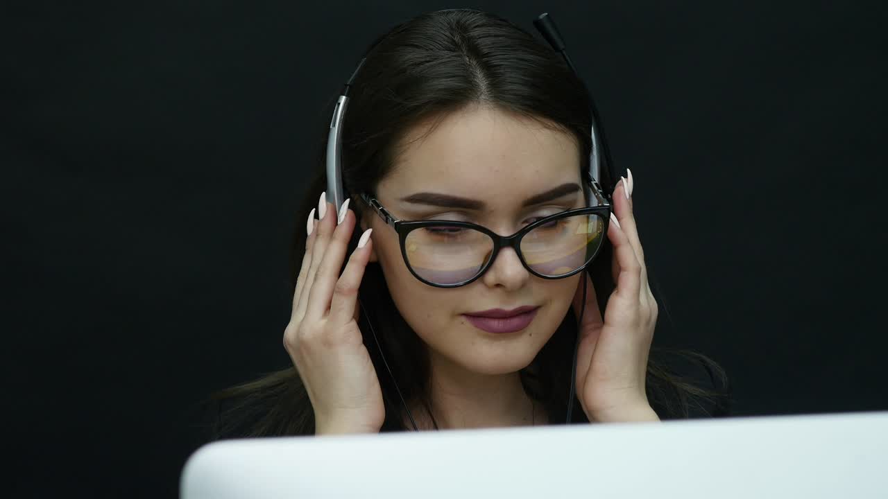 attractive business woman working with computer in office and listens to music in headphones