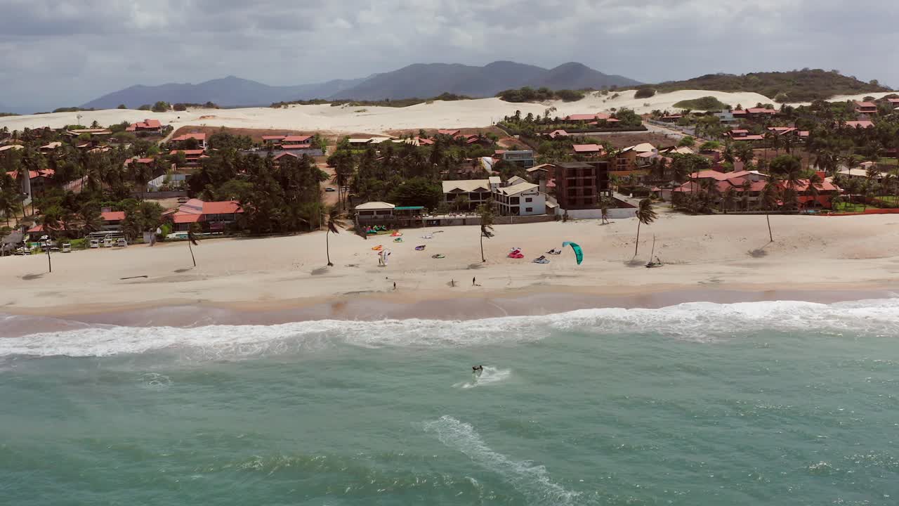 antena: cumbuco durante el día con gente haciendo kitesurf