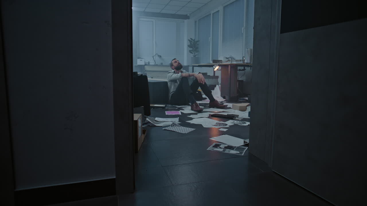 Man Sitting on the Floor in a Messy Office