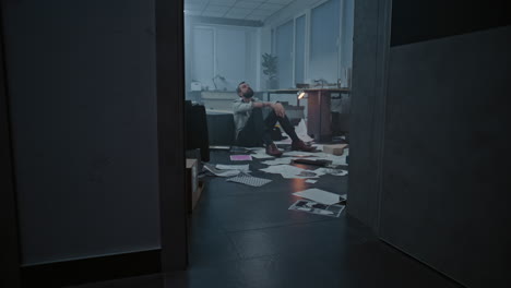 man sitting on the floor in a messy office